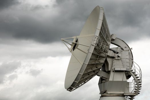 A large satellite dish stands against a dramatic cloudy sky, highlighting modern technology and communication.