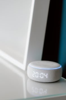 Close-up of a smart speaker with digital time display indoors.